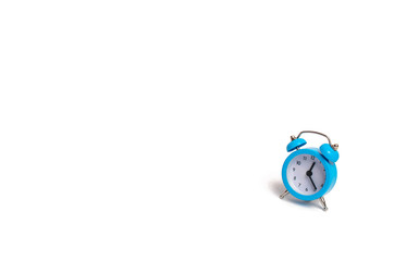 A blue alarm clock on a white background. The concept of time and planning. The past, the future...