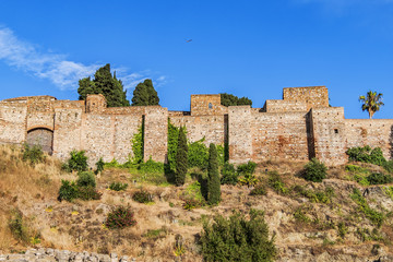 Fototapeta na wymiar External view of Alcazaba Walls - palatial fortress in Malaga built in XI century. Fortress palace, whose name in Arabic means citadel, is one of city's historical monuments. Malaga, Andalusia, Spain.