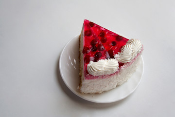Piece of cranberry cake on plate isolated on white background