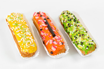Sweet and colorful eclairs. Group of french dessert Eclair on white background. custard pastry dessert with whipped cream inside
