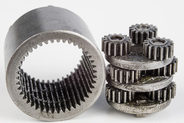 Planetary gear from a small device on a bright table. Gear wheels from a specialist device.