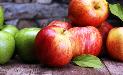 Ripe red apples and green apple on wooden background