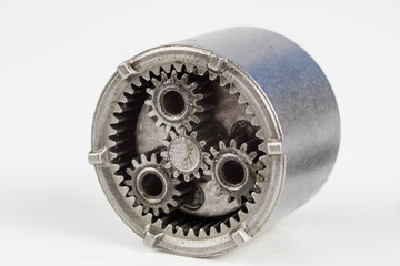 Planetary gear from a small device on a bright table. Gear wheels from a specialist device.