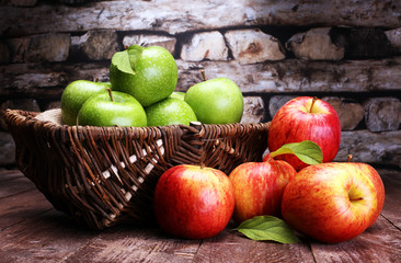 Ripe red apples and green apple on wooden background