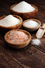 sea salt in bowl. Crystals of salt on table and himalayan salt