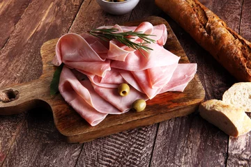 Gartenposter Sliced ham on wooden background. Fresh prosciutto. Pork ham sliced. © beats_