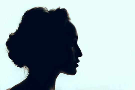 Silhouette of beautiful young woman with a beautiful hairdo