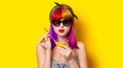 Foto op Plexiglas Young girl with purple hair holding lemonade cocktail on yellow background © Masson