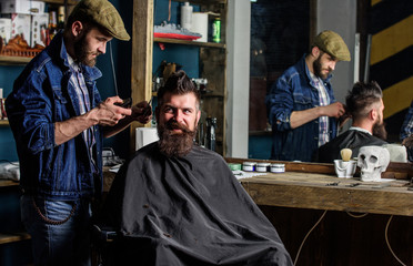 Barber and hipster client with beard checking haircut in mirror, dark background. Man with beard...
