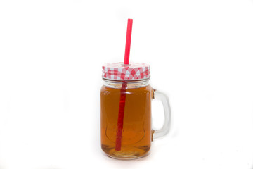 Tea in a glass with a straw isolated on a white background. Cold refreshing drink
