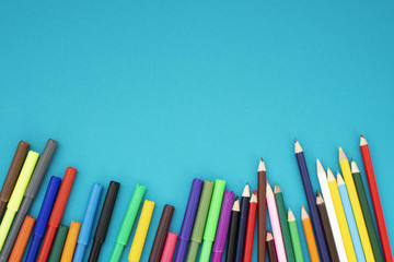 Fototapeta premium Back to school flat lay. Colour pencils on blue background. Copy space