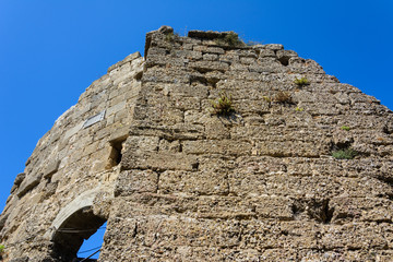 stone ruins of the walls of ancient Thermae with arch on blue sky background