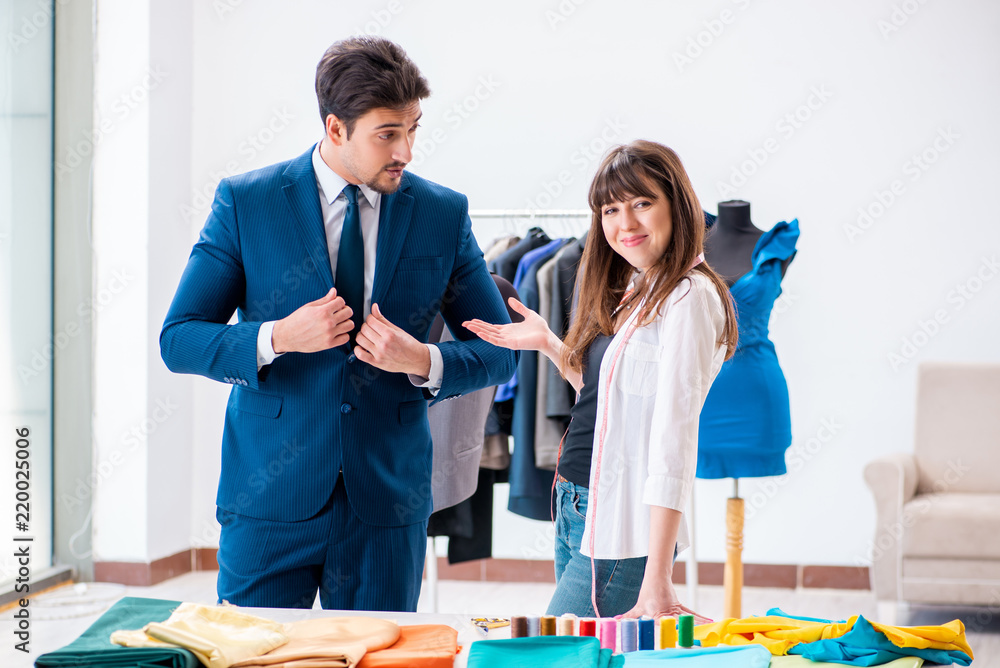 Wall mural professional tailor taking measurements for formal suit