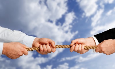 Business men hands holding rope on grey background