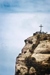 St.-Michael-Kreuz in Montserrat, Barcelona vor einem bewölkten Himmel. Reiseziel und religiöses Symbol mit leerem Kopienraum für den Text des Herausgebers. © JuanCi Studio