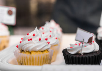 Close up photo of colorful cupcake sweet dessert with whipped cream at a street food market