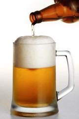 Bottle of beer being poured into a glass