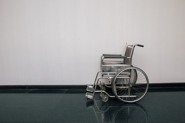 Wheel chair in the hospital corridor. Empty wheelchair parked in Patient Rooms at hospital. Empty...