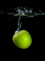 Green Apple in Water on Black Background
