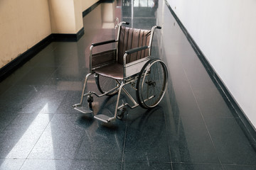 Wheel chair in the hospital corridor. Empty wheelchair parked in Patient Rooms at hospital. Empty...
