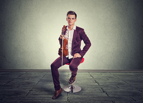 Young man holding violin and fiddlestick
