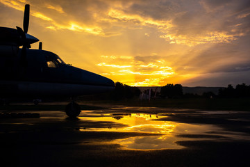 Modern airplane silhouette at sunset on the ground