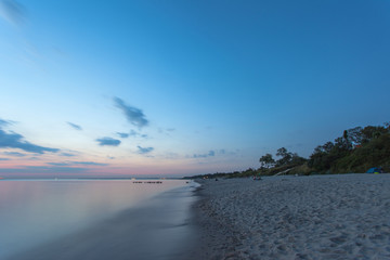 smooth sea surface and coast in blue twilight on long exposure
