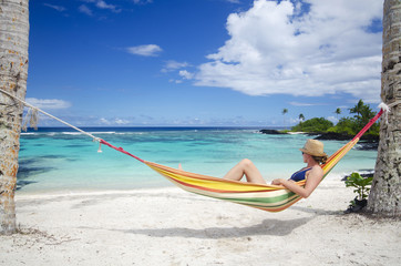 Woman relaxing in hammock on beach