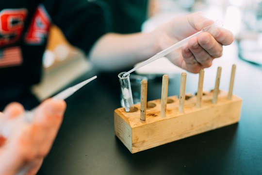 Student filling test tube in science laboratory 