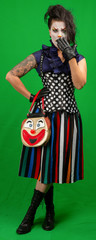 Female creepy clown standing. Isolated on green screen.