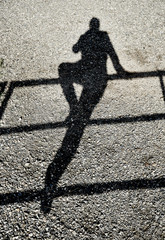 Shadow person balancing on a rail