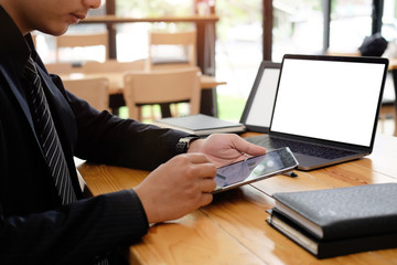 Cropped shot of Businessman working with laptop and tablet analysis data on office table.