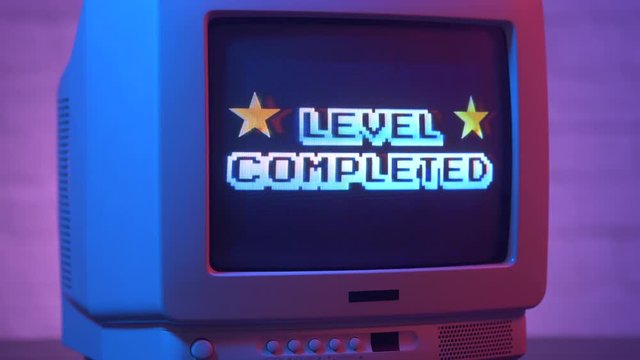 Level Completed flashing on a retro video game TV from the 80s or 90s. Vintage CRT screen in a 1980 1990 visual style.