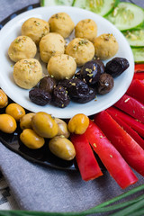 Buddha bowl with chickpea falafel balls, tomato sauce, olives, cucumbers, red pepper. Vegan vegetables lunch, vegetarian dinner, healthy dietary food