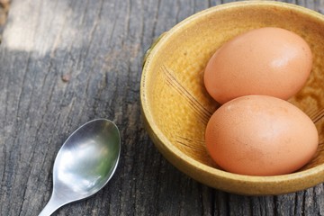 2 eggs in bowl on rustic wood background