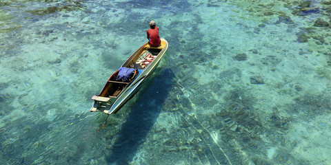Fototapeta premium Fisherman in his boat on turquoise sea