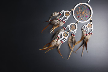 Dream catcher with feathers threads and beads rope hanging spiritual folk american native indian amulet isolated on black background.Copy space for text.Concept prevent evil in Halloween.