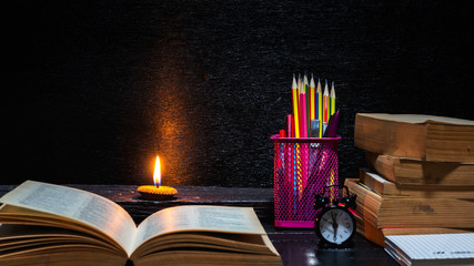 Book,Accessories,pencils, with lighting candle at night time,Back to School,Education concept,