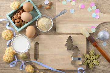 Prepare cooking cookies for celebration, top view of equipment for decor and cookies ingredients such as eggs, sugar, flour and almonds on wooden plate and table.