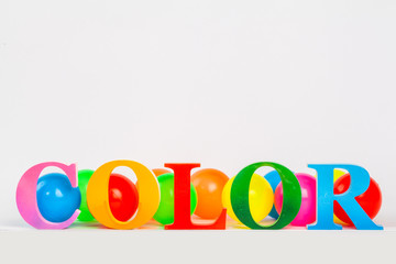 Colorful letters of the word color and colorful ball on the white background.