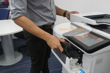 office printer run out of ink and required toner cartridge put by businessman