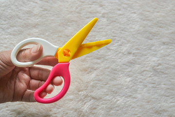 woman left hand with zigzag scissors for craft work