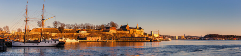 Fototapeta na wymiar Panorama of Oslo city skyline and harbor in front of Akershus Fortress during sunset in Norway