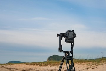 A camera on a tripod for taking a panorama in the open air