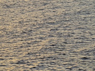 View at Water Surface with Small Waves during Sunset