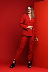 Fashion young woman in red suit.