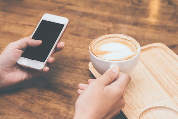 Close up of  woman hands holding touching mobile phone with blank copy space for your text message in cafe with light Sunset,Vintage tone.Selective focus