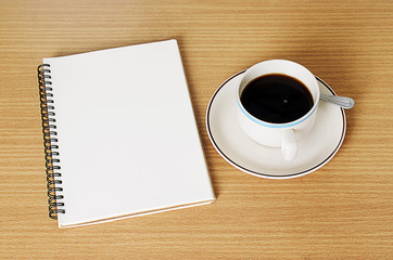 Obraz na płótnie Canvas Black Coffee cup with notebook on wood table