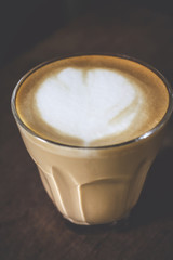 Latte art in cup on wood table in the morning at home, copy space for your text