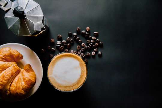 Latte Art ,Croissant And Moka Pot With Roasted Coffee On Black Background In The Morning Top View And Instagram Style Filter Photo Vintage Tone